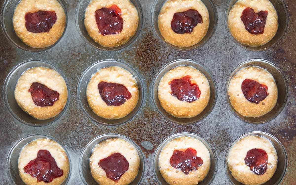 Dollops of strawberry jelly hide inside the center of each peanut butter muffin