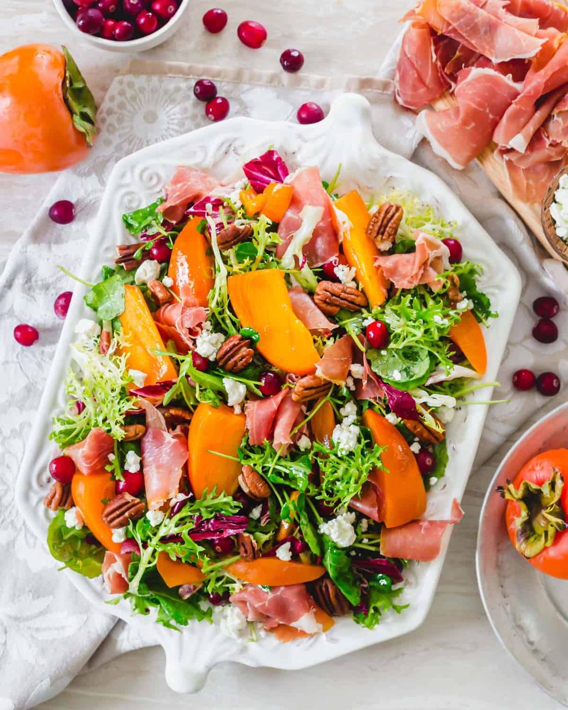 Winter persimmon salad recipe on a white serving platter.