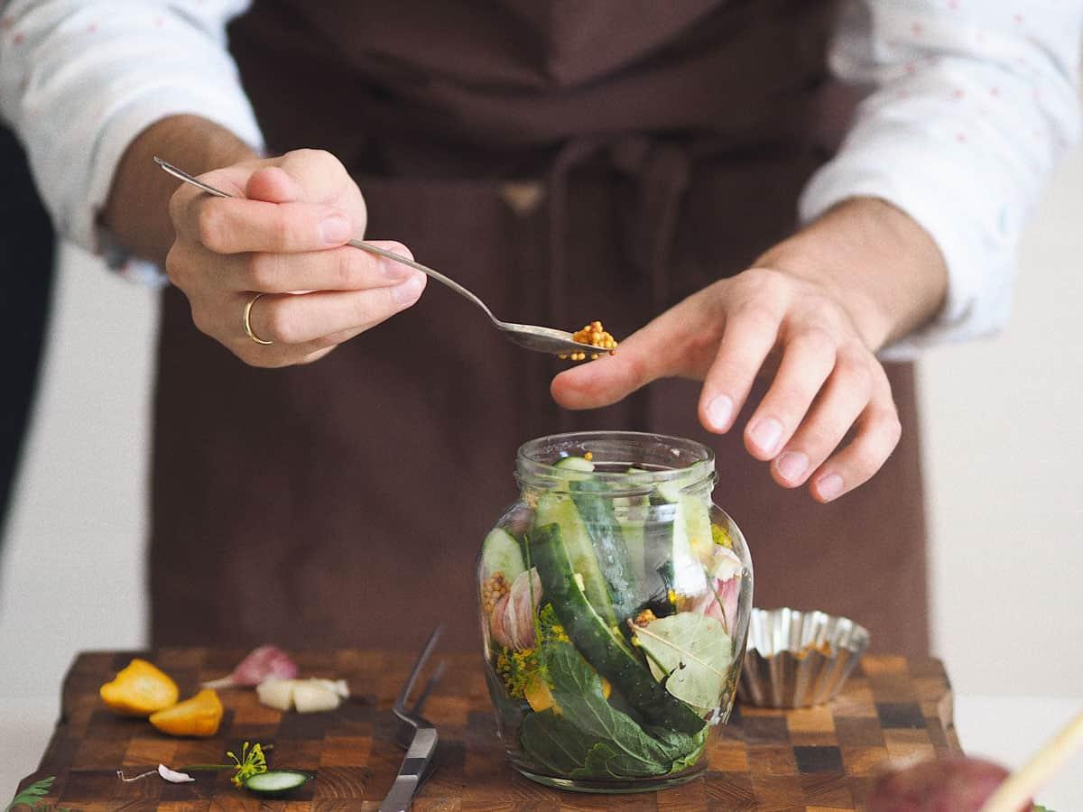 Adding seasoning to quick pickles.