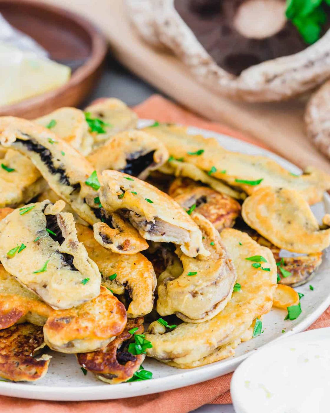 Inside of a battered pan fried portobello mushroom on a plate.