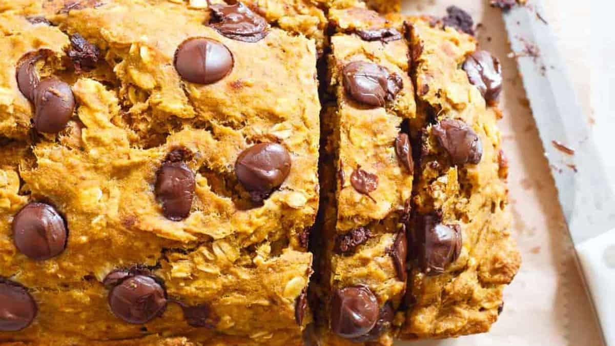 A slice of pumpkin chocolate chip bread on a cutting board.