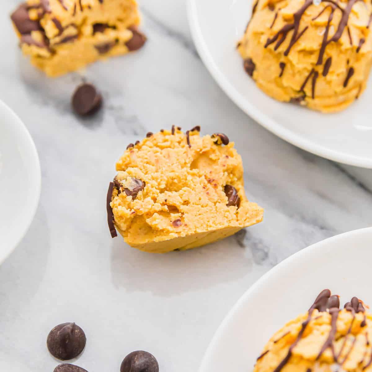 Soft, no-bake pumpkin cookie dough studded with mini chocolate chips and drizzled with melted chocolate
