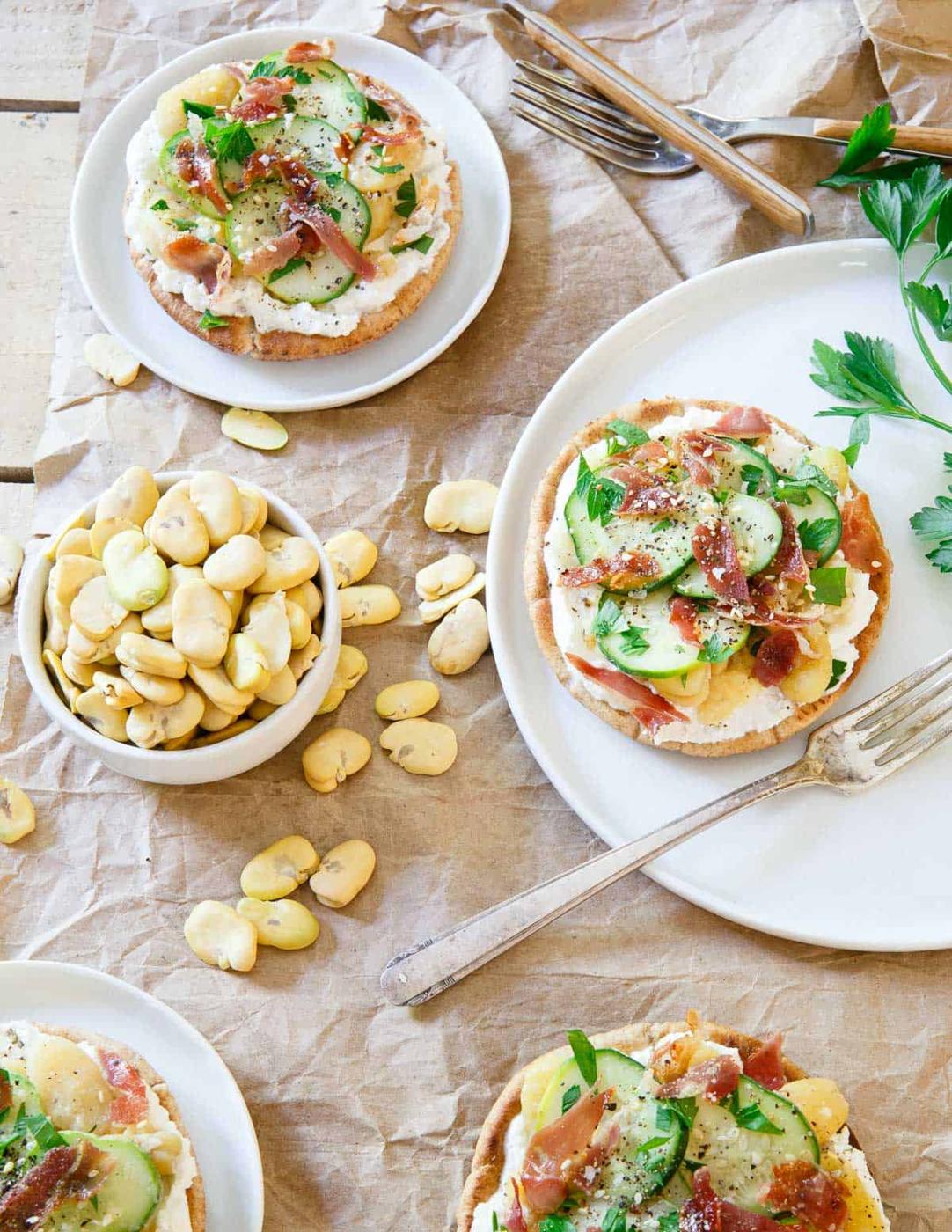 These fava bean grilled pita bites are layered with a base of creamy ricotta, tangy pickled cucumbers and crisp salty prosciutto. They make a sensational bite for a light lunch or appetizer!