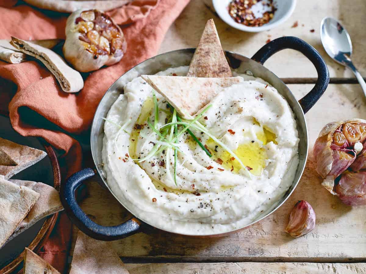 A whole head of roasted garlic is added to this creamy white bean dip along with a secret ingredient bringing a healthy protein boost to each bite!