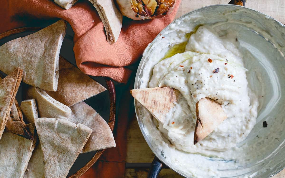 Serve this roasted garlic white bean dip with plenty of toasted pitas and vegetables for an easy and healthy crowd-pleasing appetizer.