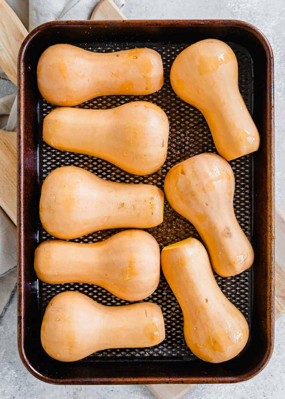 Honey patch squash cut side down on a baking sheet.