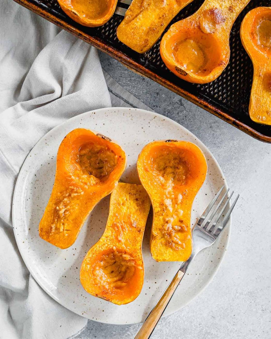 Roasted honey patch squash on a white plate with a fork.