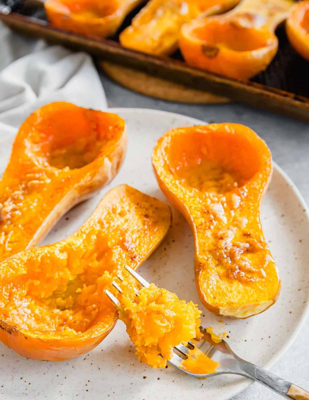 Roasted squash on a plate with a forkful scooped out.