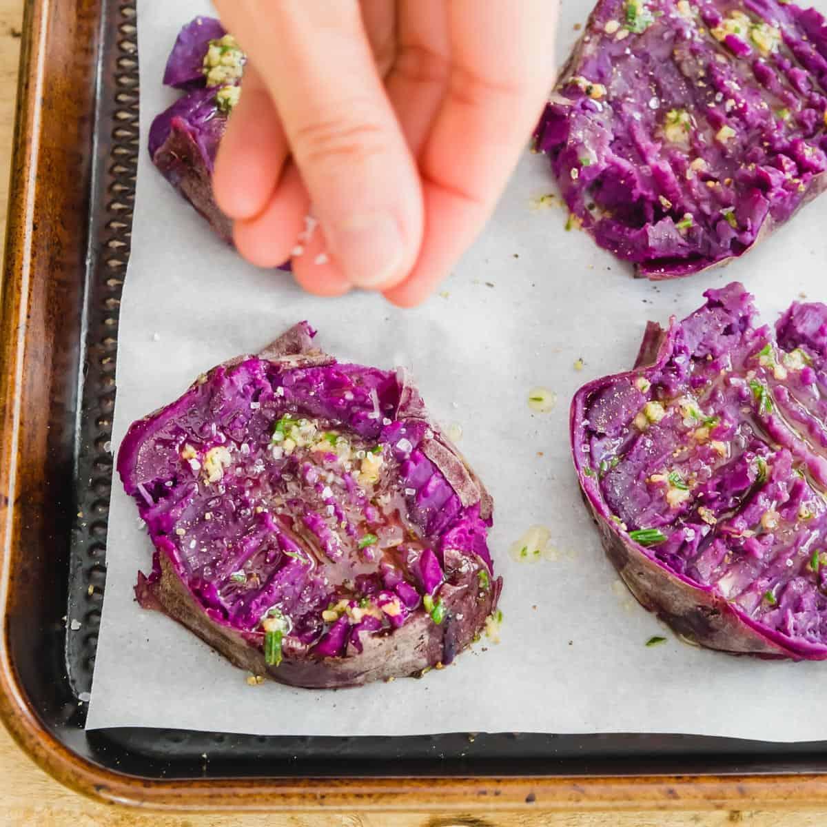 Smashed purple sweet potatoes before being broiled until crispy in the oven.