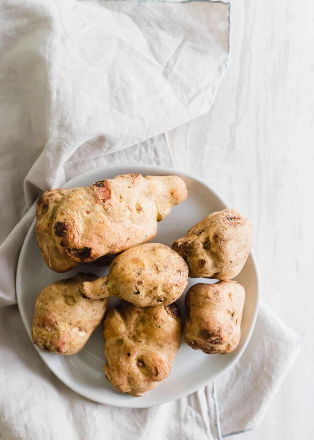 Raw sunchokes, also known as jerusalem artichokes on a plate.