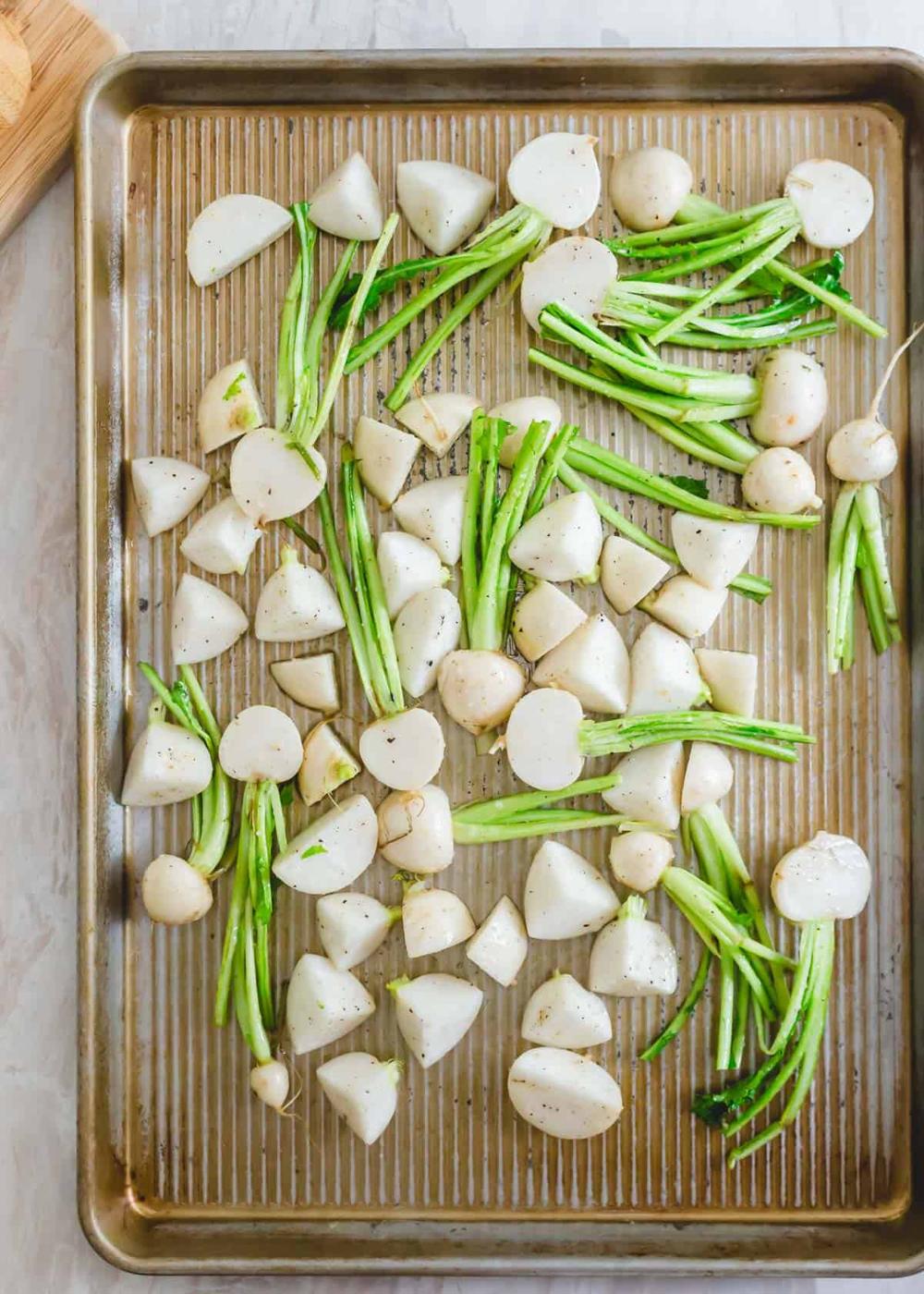 Chopped turnips prepped for roasting on a baking sheet.