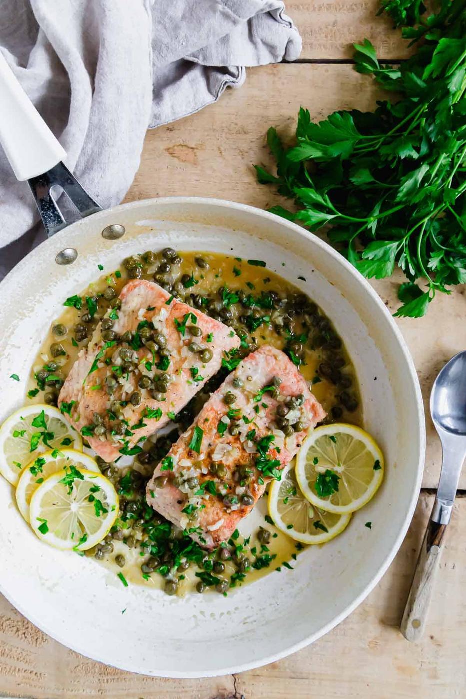 Salmon piccata recipe in a white pan.