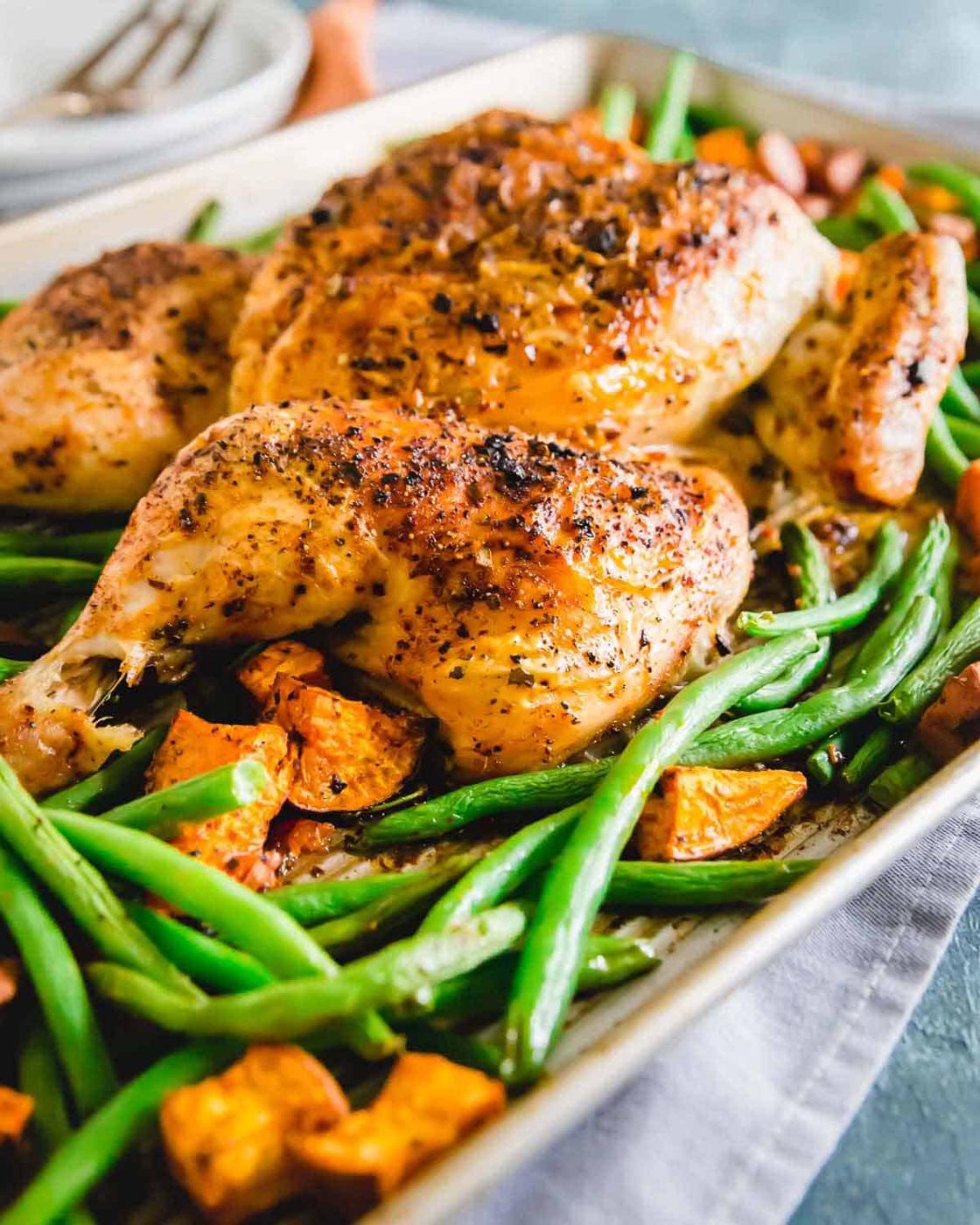 Piri piri spice chicken roasted on a sheet pan with green beans and sweet potatoes.