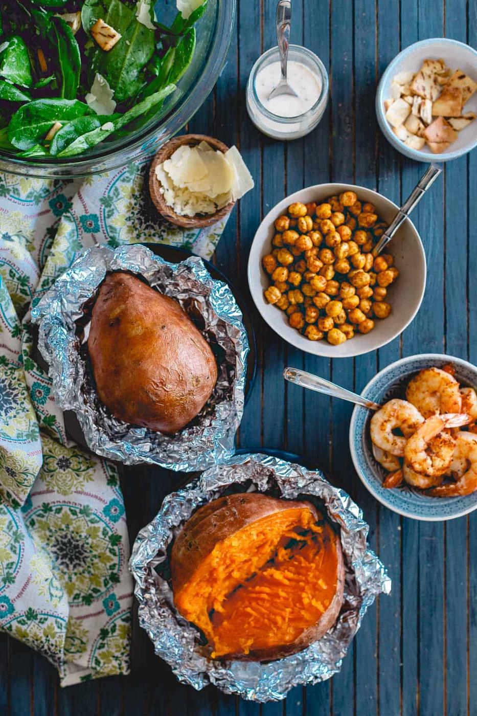 Add roasted chickpeas and spicy shrimp to these caesar salad stuffed sweet potatoes for a filling and healthy meal.