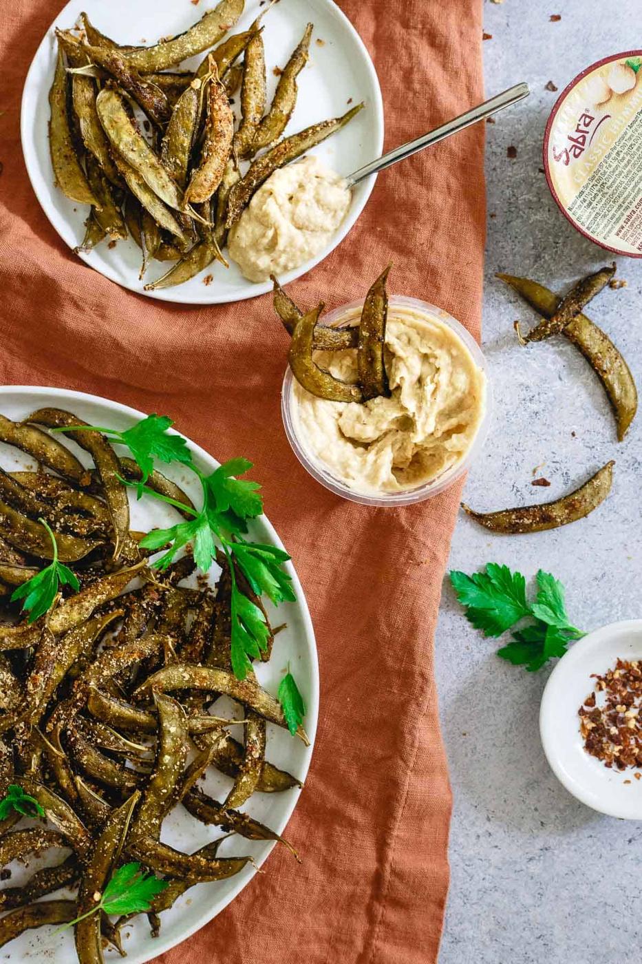 Dipping snap pea crisps into hummus.