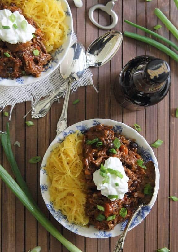 Spicy short rib chili in a bowl with a large spoon with spaghetti squash