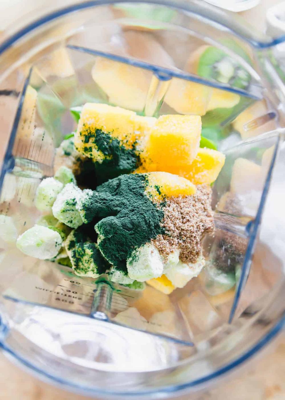 spirulina, mango, banana, kiwi, baby greens and flax seeds in the blender to make a smoothie