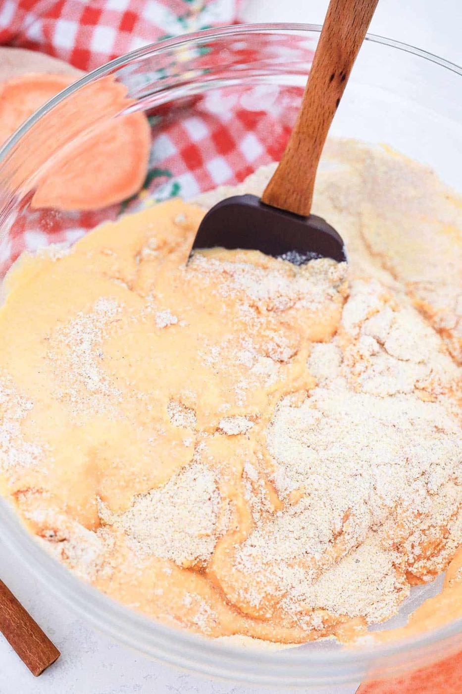 Mixing together ingredients to make sweet potato cornbread in a skillet.