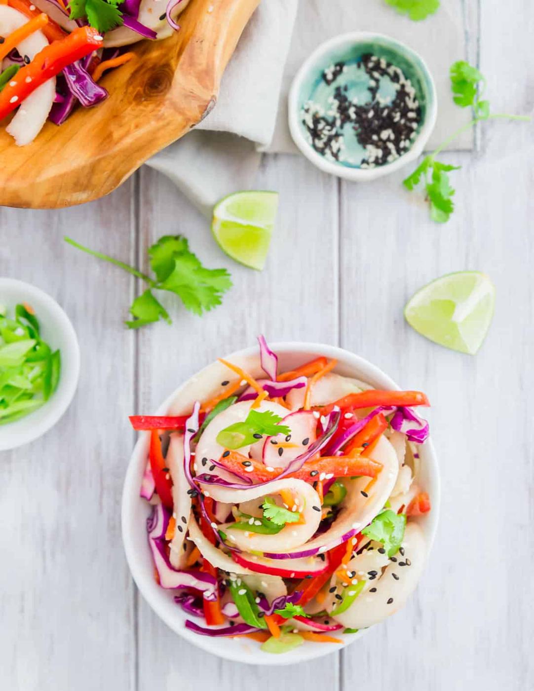 Spiralized kohlrabi noodles make the base of this healthy Thai inspired salad with cabbage, red peppers, carrots, radish, jalapeño and green onion in a simple Asian flavored vinaigrette.