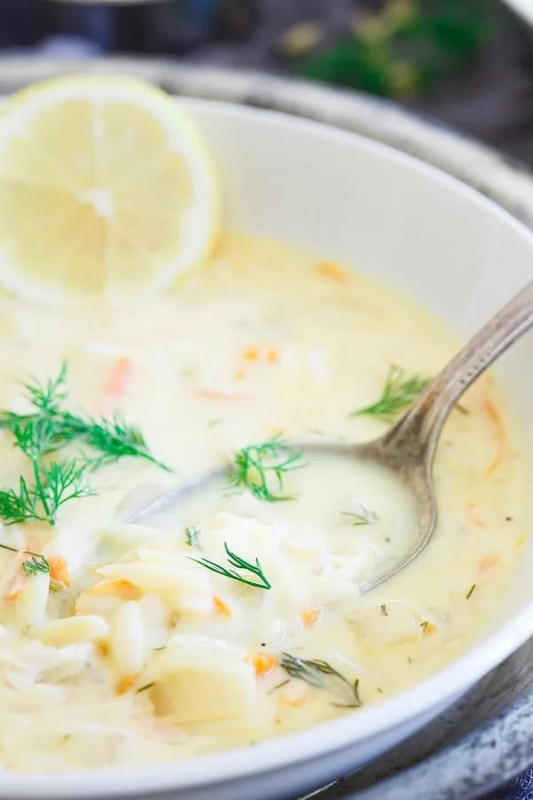 Greek Lemon Orzo Turkey Soup topped with garnish in a white bowl.