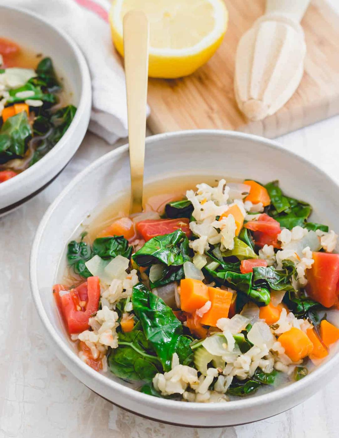 Tuscan kale soup in a bowl with a serving spoon and lemon.