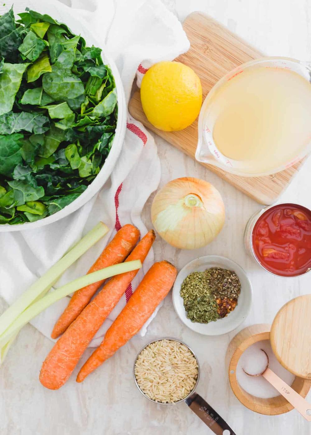 Ingredients to make Tuscan kale soup - Tuscan kale leaves, broth, diced tomatoes, yellow onion, celery, carrots, brown rice, herbs and spices.