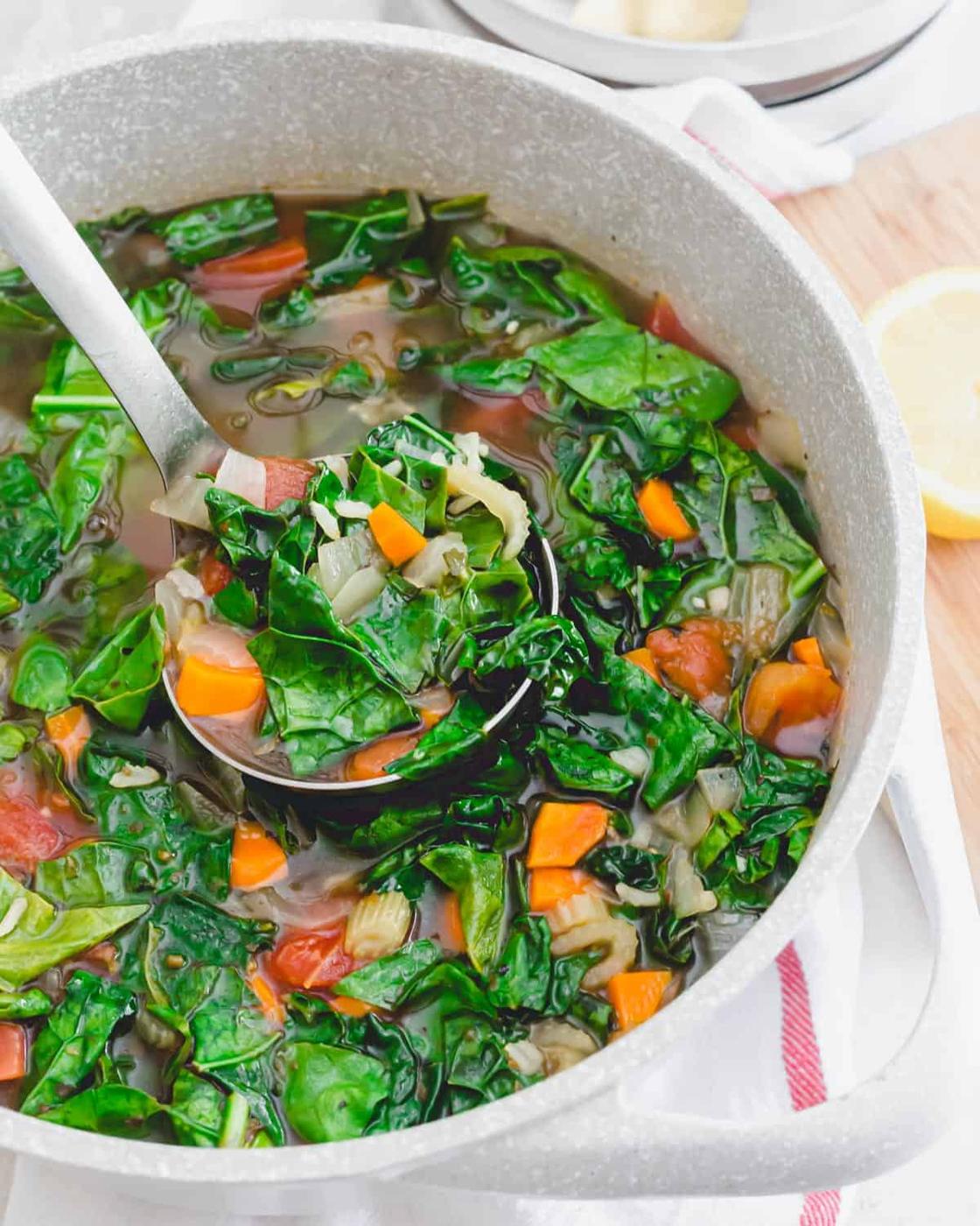 A pot of healthy vegetarian kale soup with brown rice.