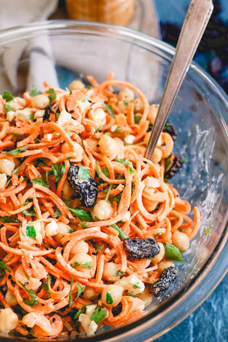 Mediterranean carrot salad with yogurt tahini dressing in a glass bowl.