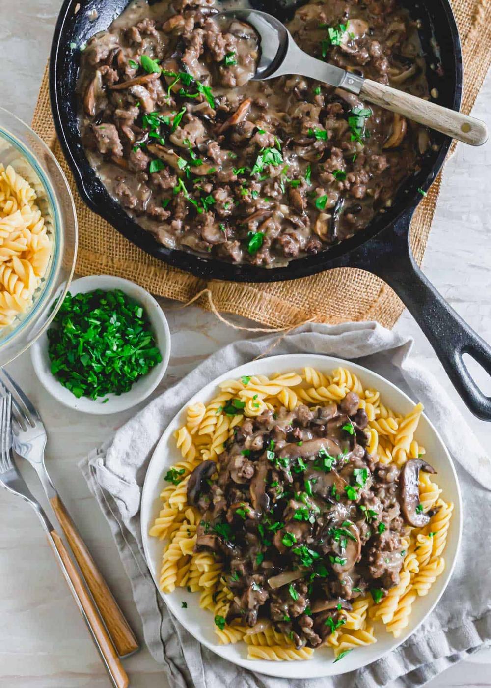 Top down shot of dairy-free venison stroganoff served over gluten-free rotini garnished with fresh parsley.