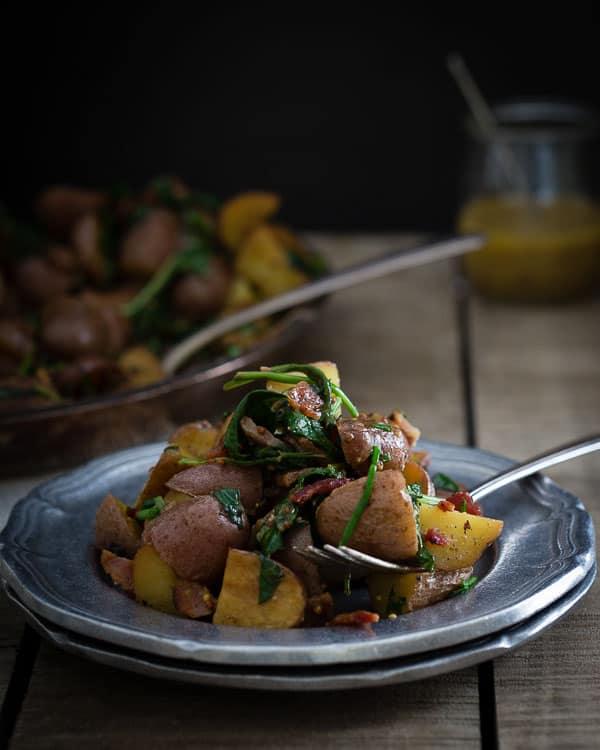 Warm potato salad with bacon and greens