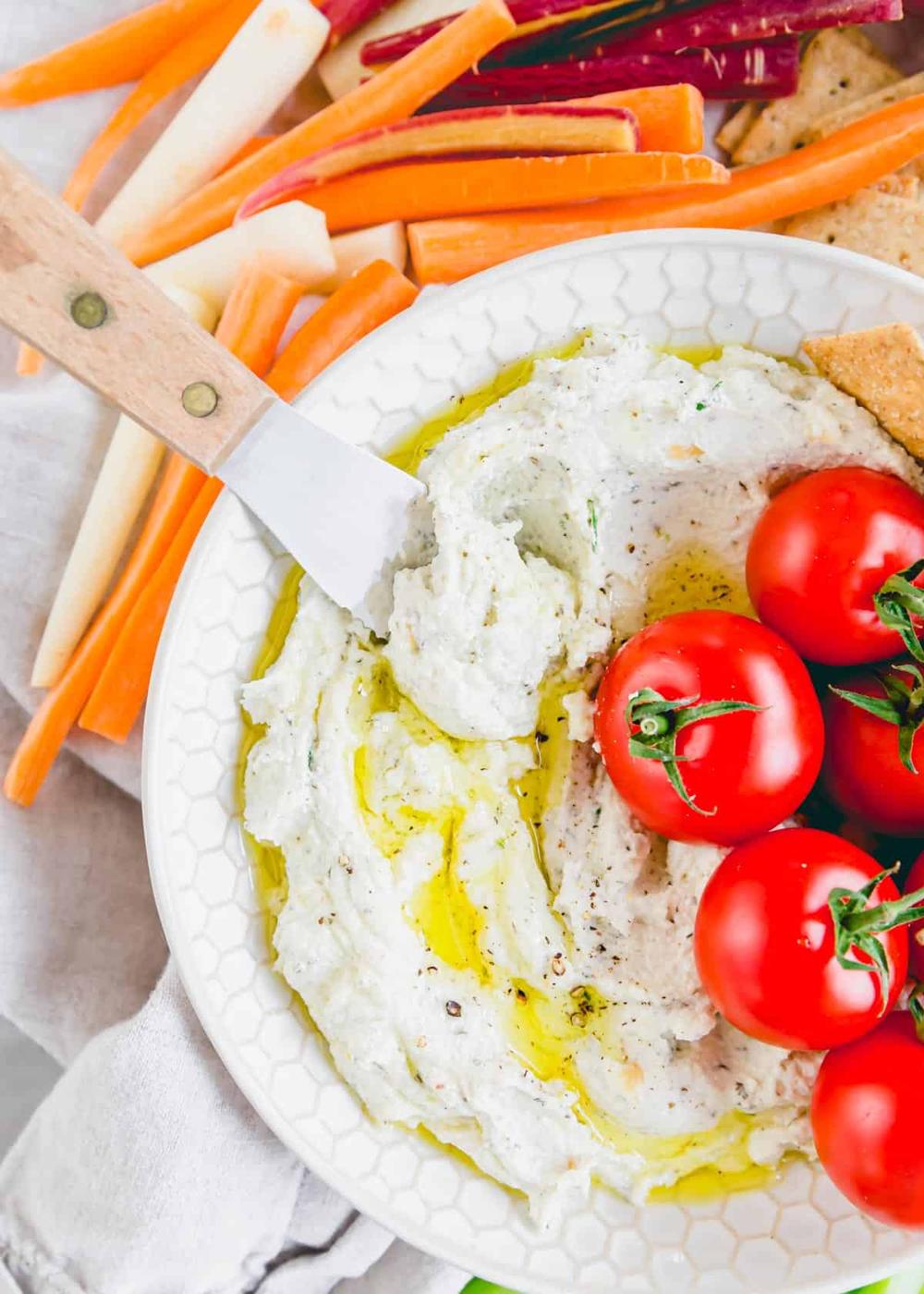 Creamy garlic whipped goat cheese with a small spatula.