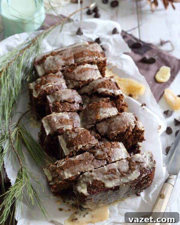 Tea-Kissed Dark Chocolate Gingerbread Loaf 2 A delectable slice of tea-glazed chocolate gingerbread loaf, showcasing its rich brown hue and sweet, glistening topping, perfect for holiday indulgence.