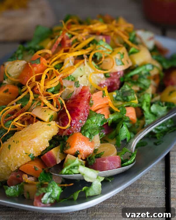 Close-up of the chopped carrot citrus salad, showing the texture of roasted carrots, the juiciness of blood oranges and Meyer lemons, and the freshness of herbs, all coated in a light vinaigrette.