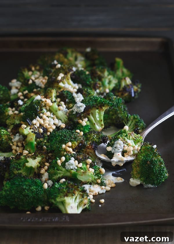 Close-up of Girl and the Goat's signature Grilled Broccoli, perfectly charred and drizzled with sauce.