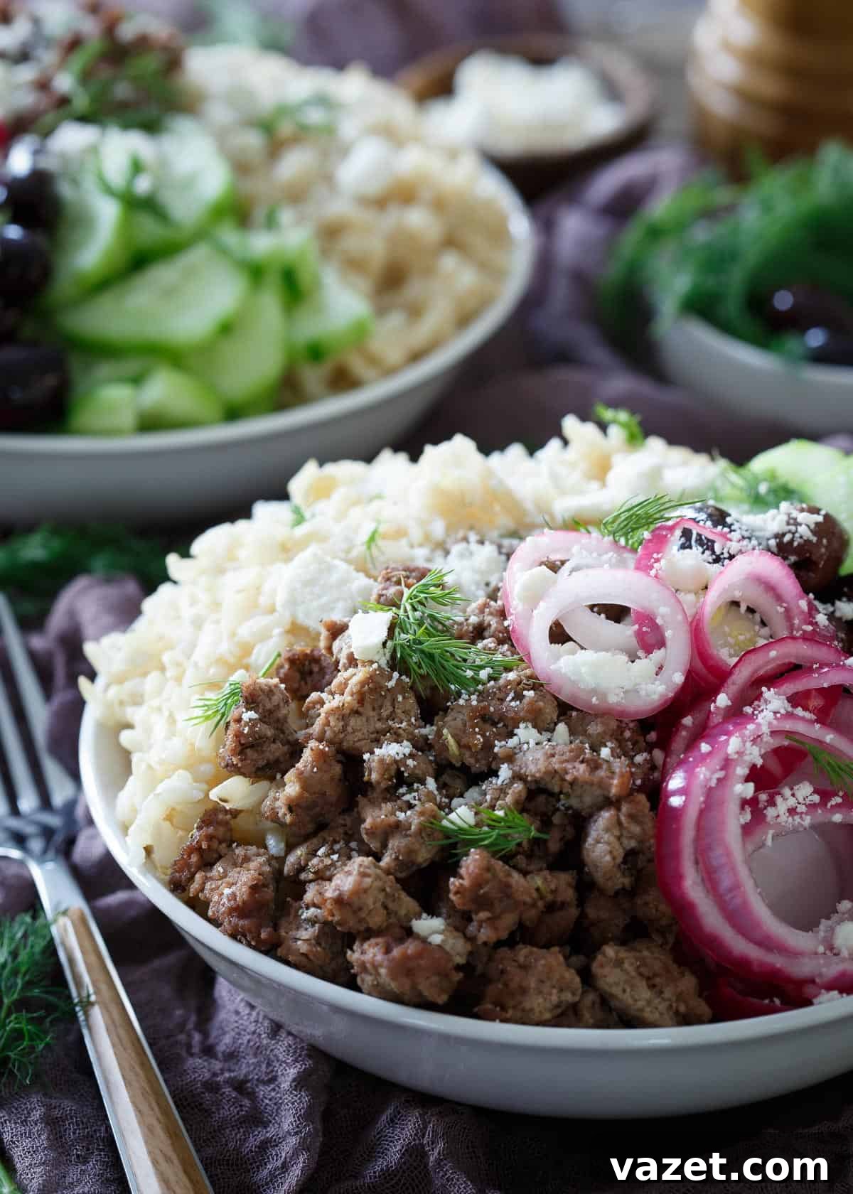 Greek Brown Rice Bowls: Gyro and Greek Salad Fusion Close-up of a Greek Brown Rice Bowl bursting with colorful ingredients like lamb, pickled onions, and feta