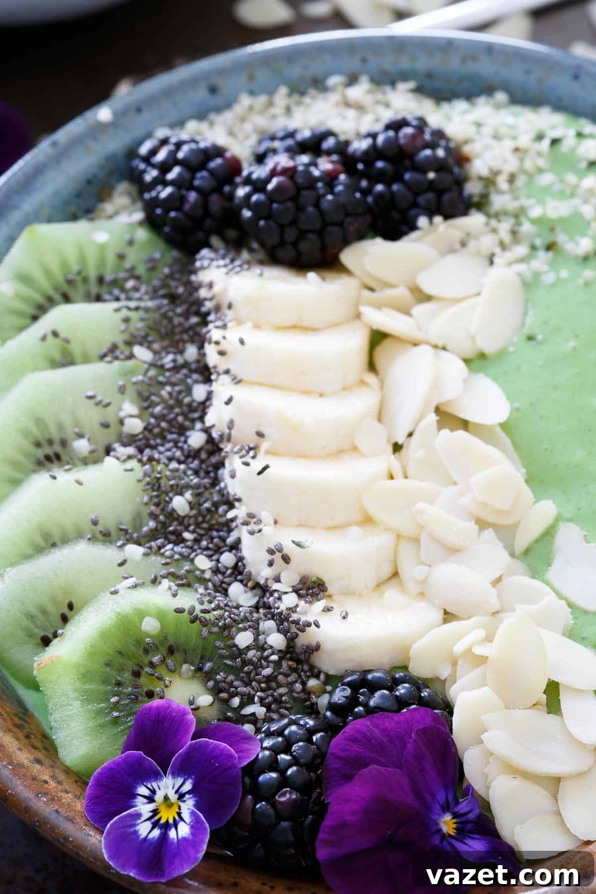 Avocado Pineapple Smoothie Bowls: A Wholesome Breakfast Choice Close-up of a vibrant avocado pineapple smoothie bowl with a spoon, highlighting the creamy texture and colorful toppings.