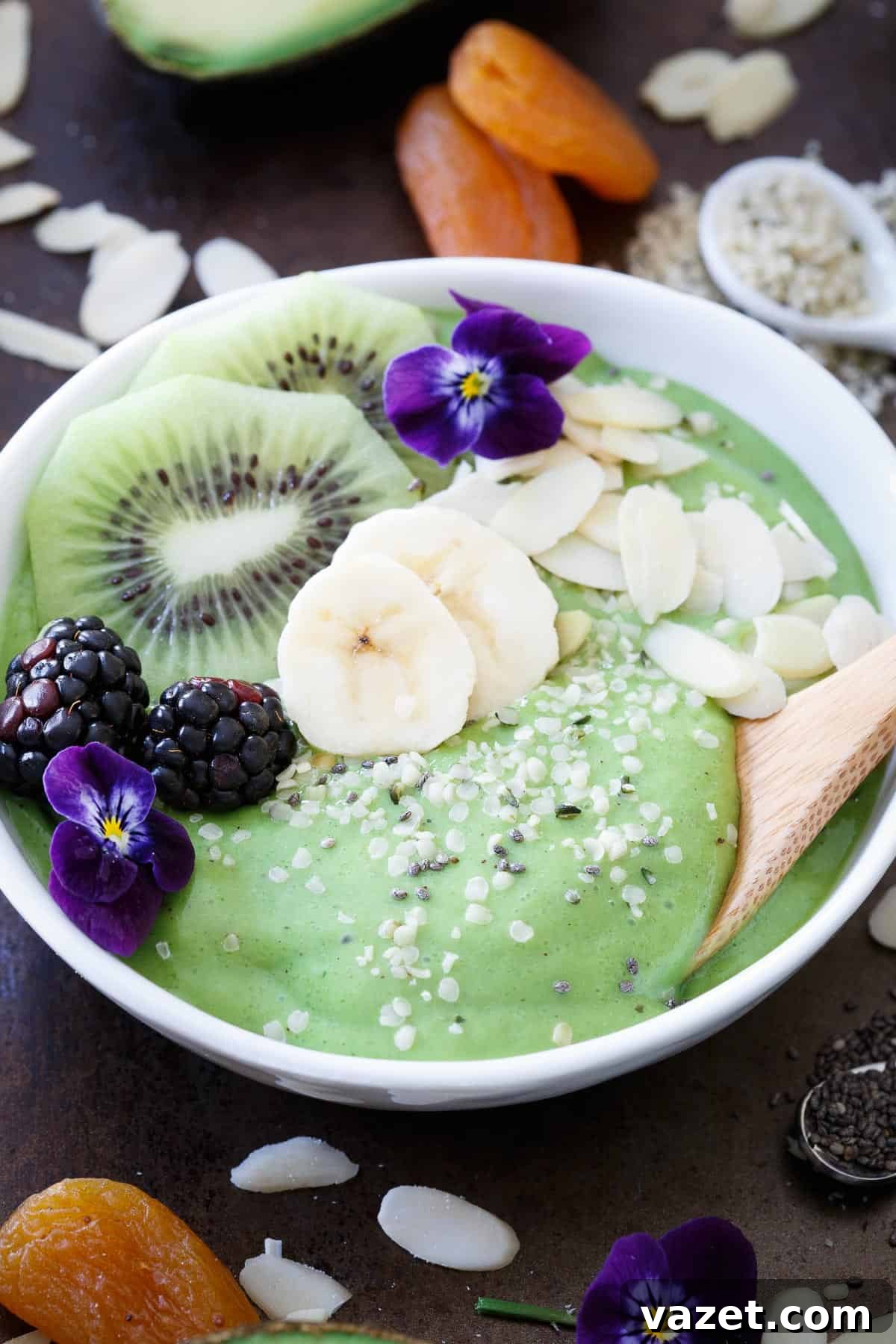 Superfood Avocado Pineapple Smoothie Bowls for a Nutritious Start Overhead view of an avocado pineapple smoothie bowl garnished with blackberries, kiwi slices, and edible flowers for a beautiful presentation.