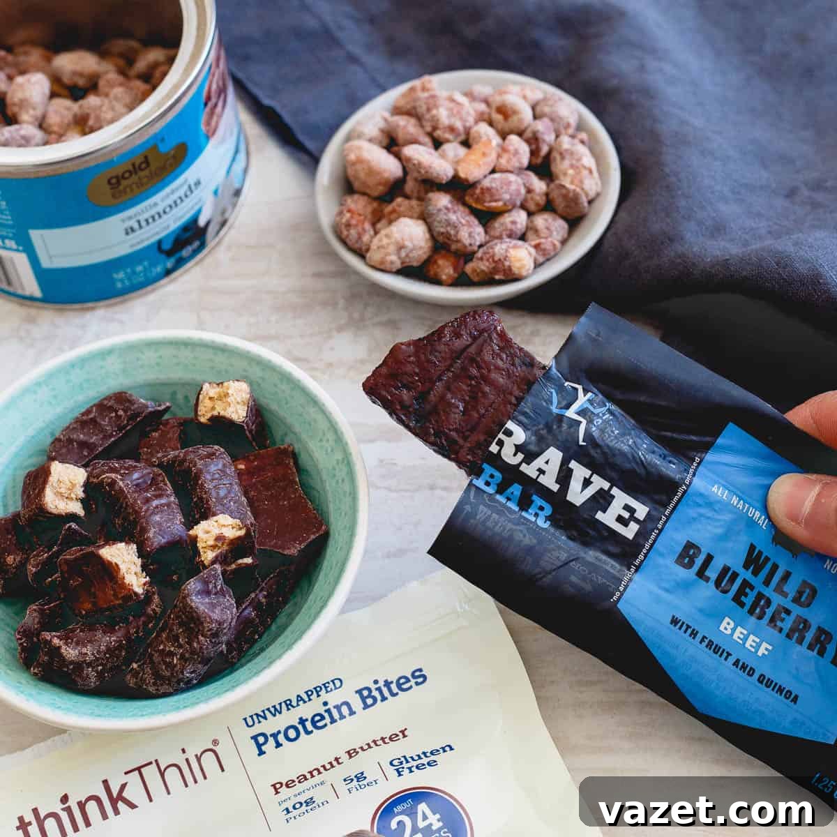A protein-packed afternoon snack idea featuring mixed nuts, chocolate-covered peanut butter protein bites, and Krave jerky bars, ideal for pre-workout fuel or sustained energy, all found at CVS.