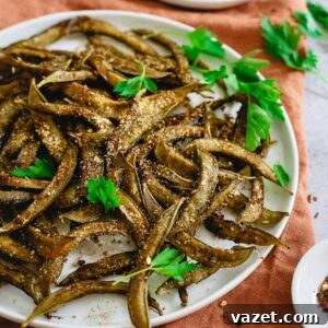 Homemade snap pea crips on a plate with herbs.