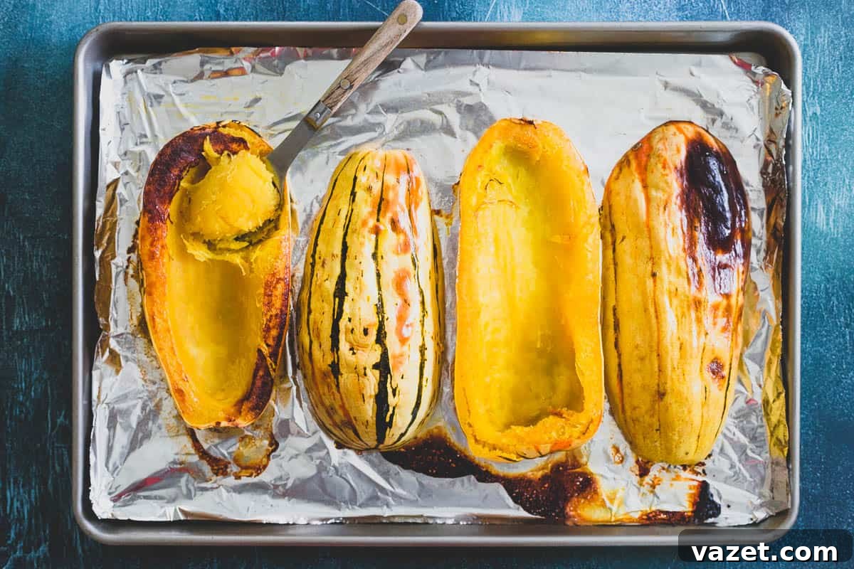 Roasting Delicata Squash Enhances its Sweetness and Deepens Soup Flavor Halved delicata squash roasting on a baking sheet, showcasing its vibrant flesh and striped skin before being transformed into a creamy soup.