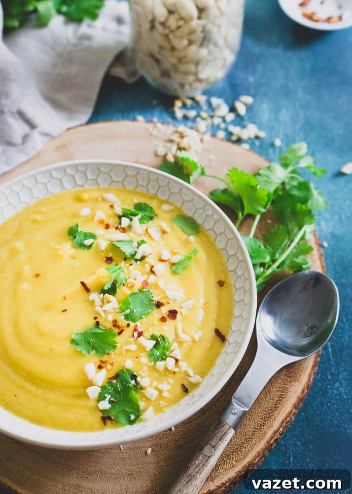 Light and Comforting Delicata Squash Soup for a Wholesome Winter Meal A close-up of creamy delicata squash soup with coconut milk, garnished with fresh herbs and a hint of spice, served in a rustic bowl.