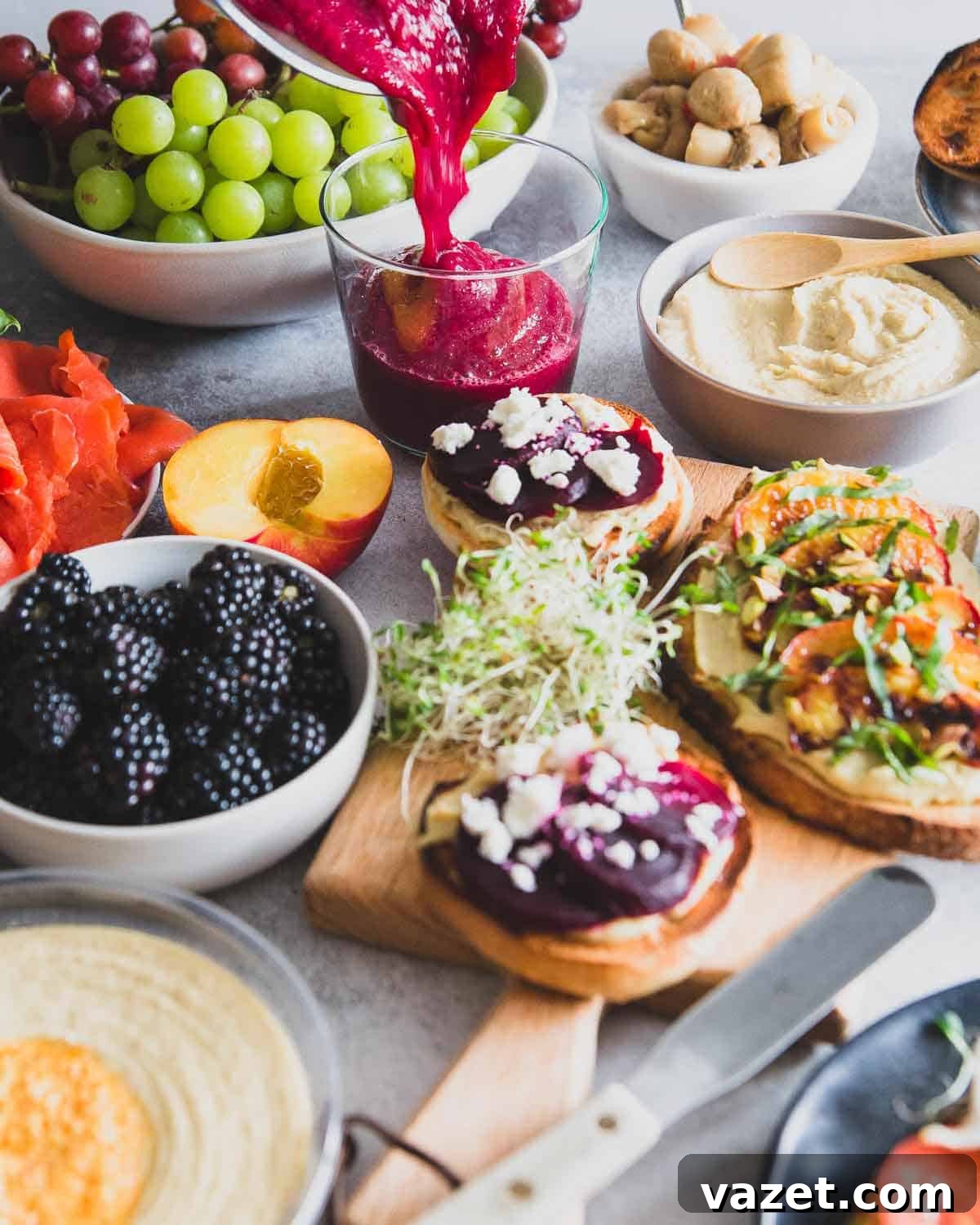 Vibrant red beet smoothie alongside a delicious hummus toast brunch spread, perfect for a healthy and energizing start to the day.