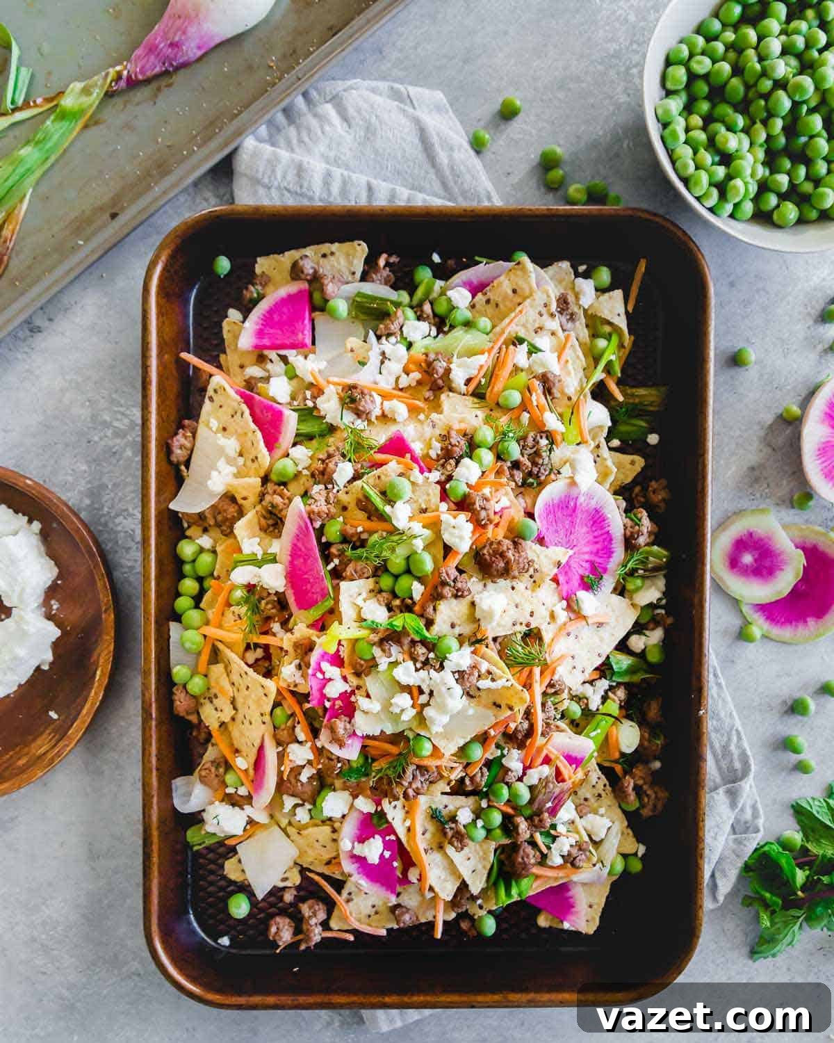 Loaded Spring Lamb Nachos 2 These ground American lamb nachos with carrots, onions, peas and radishes are topped with crumbled feta cheese for a bright and fresh spring take on nachos. Enjoy them straight off the baking sheet for an easy seasonal dinner or appetizer.