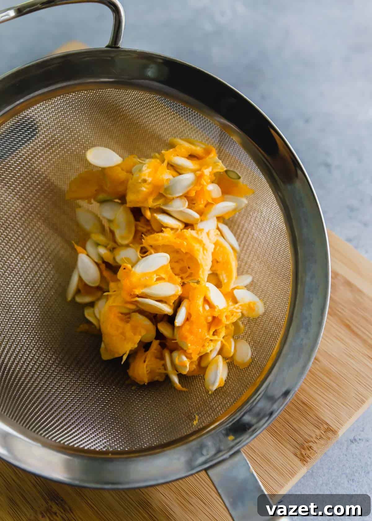 squash seeds before cleaning with pulp still attached in a colander. squash seeds before cleaning with pulp still attached in a colander.