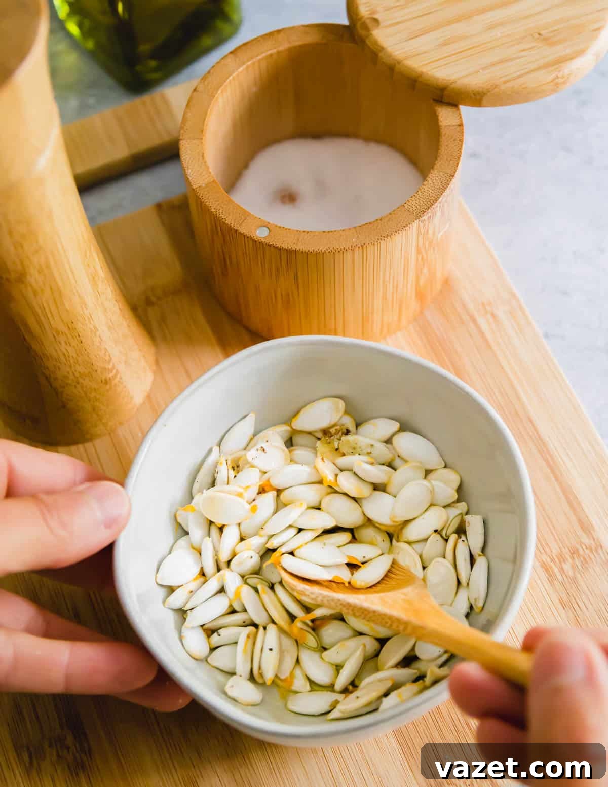 seasoning squash seeds with olive oil, kosher salt and black pepper before roasting seasoning squash seeds with olive oil, kosher salt and black pepper before roasting