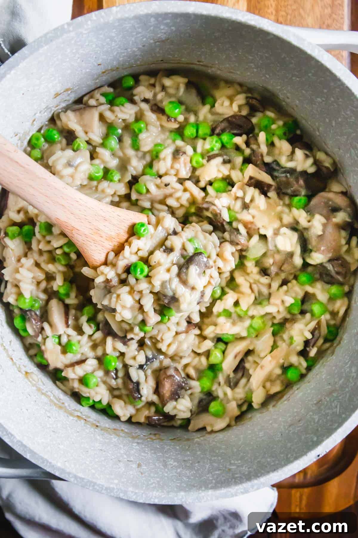 A beautifully presented bowl of creamy vegan mushroom risotto with vibrant green peas, garnished with fresh herbs, showcasing its rich texture and inviting aroma.