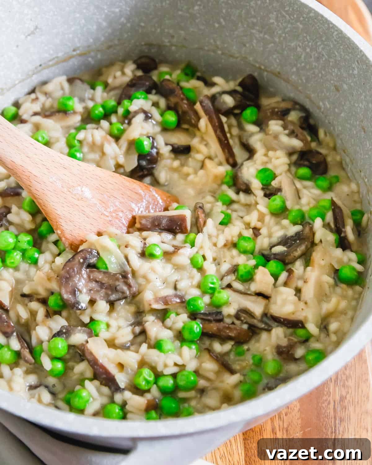 Close-up shot of a pot of easy vegan risotto with mushrooms and peas simmering, highlighting its rich, creamy texture and vibrant ingredients.