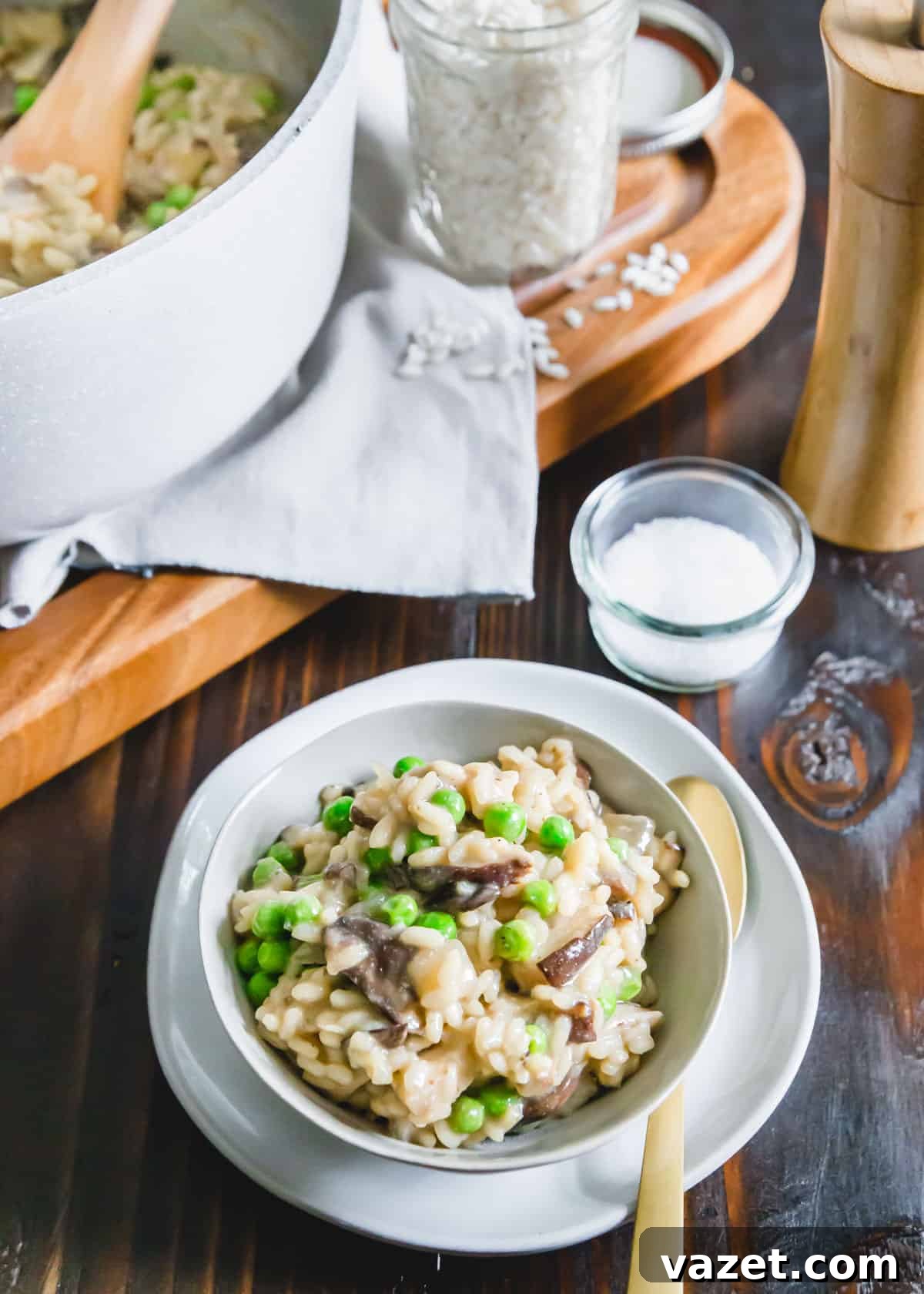A simple, one-pot recipe for dairy-free, creamy vegan mushroom risotto with frozen peas, ready to be served from a large pot.