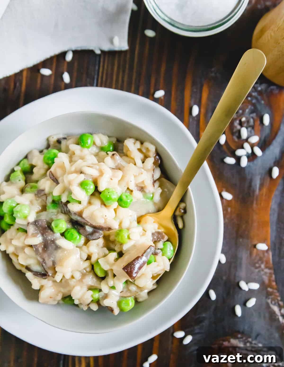 A close-up of creamy, decadent and rich vegan mushroom and pea risotto in a bowl, garnished with fresh parsley.