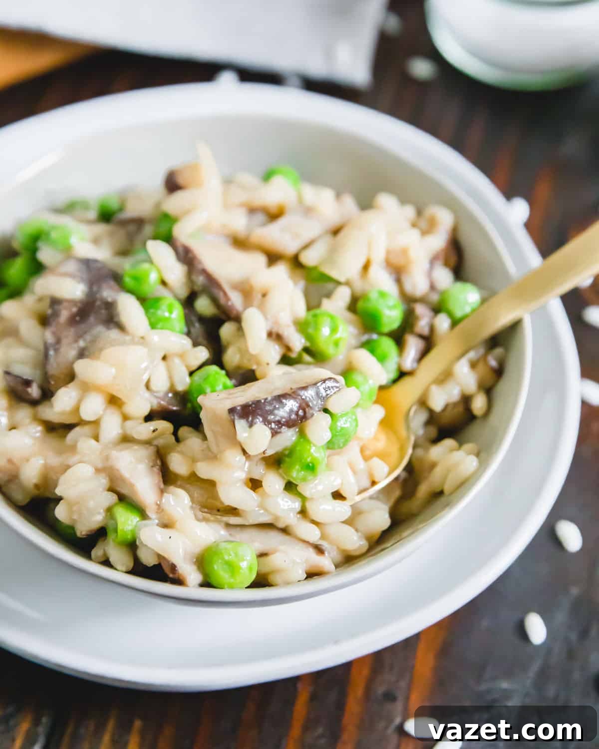 A top-down view of dairy-free, gluten-free, vegan mushroom risotto with peas and nutritional yeast, served in a rustic bowl.